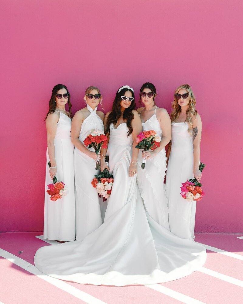 bridesmaids and bride in front of pink wall at penthouse at riverside wharf​