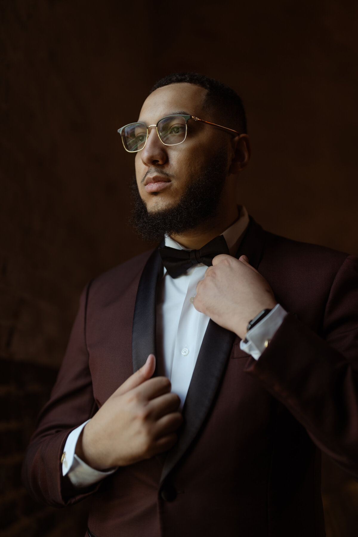 A poised shot of the groom adjusting his bow tie, presenting classic wedding fashion for Dallas grooms.