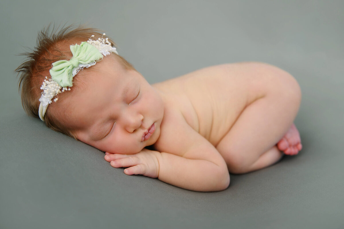 newborn girl on a green background for her Burlington, Ontario newborn photos