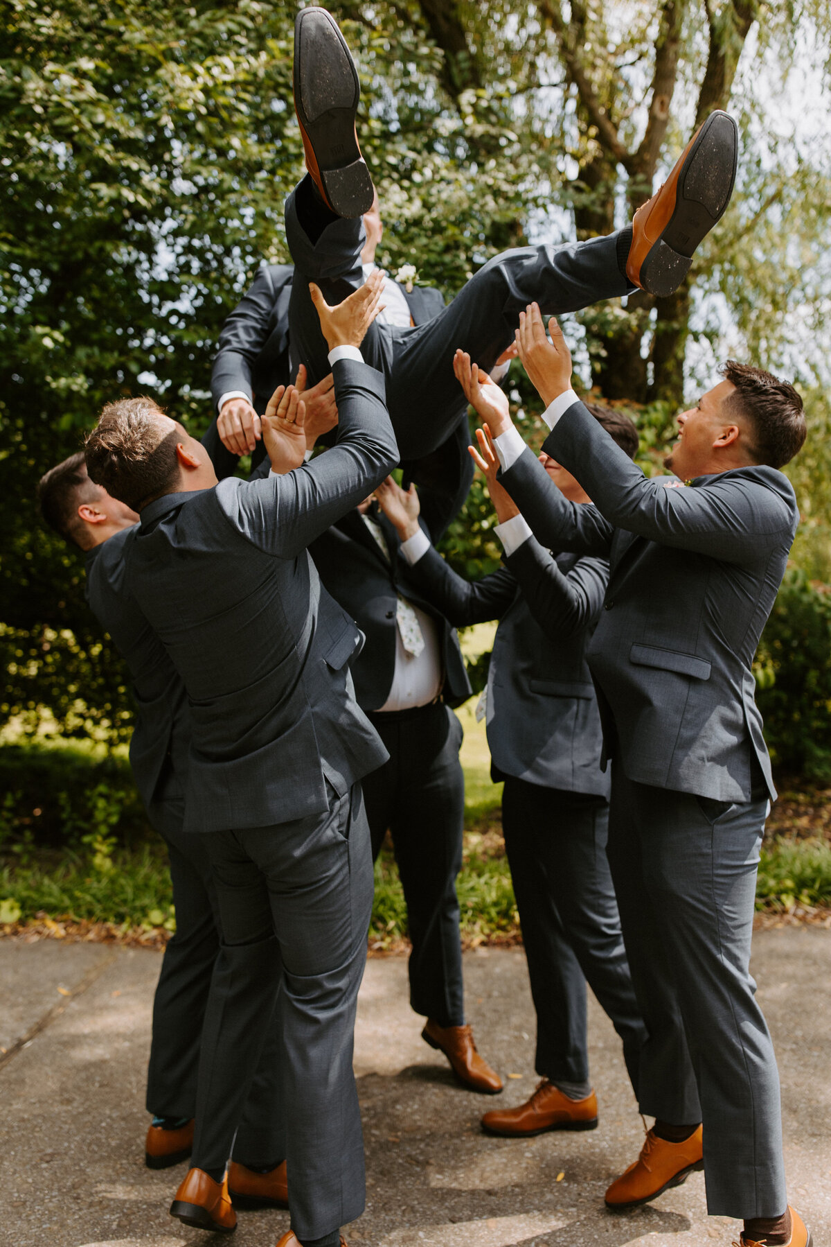 groomsmen holding up the groom in the air