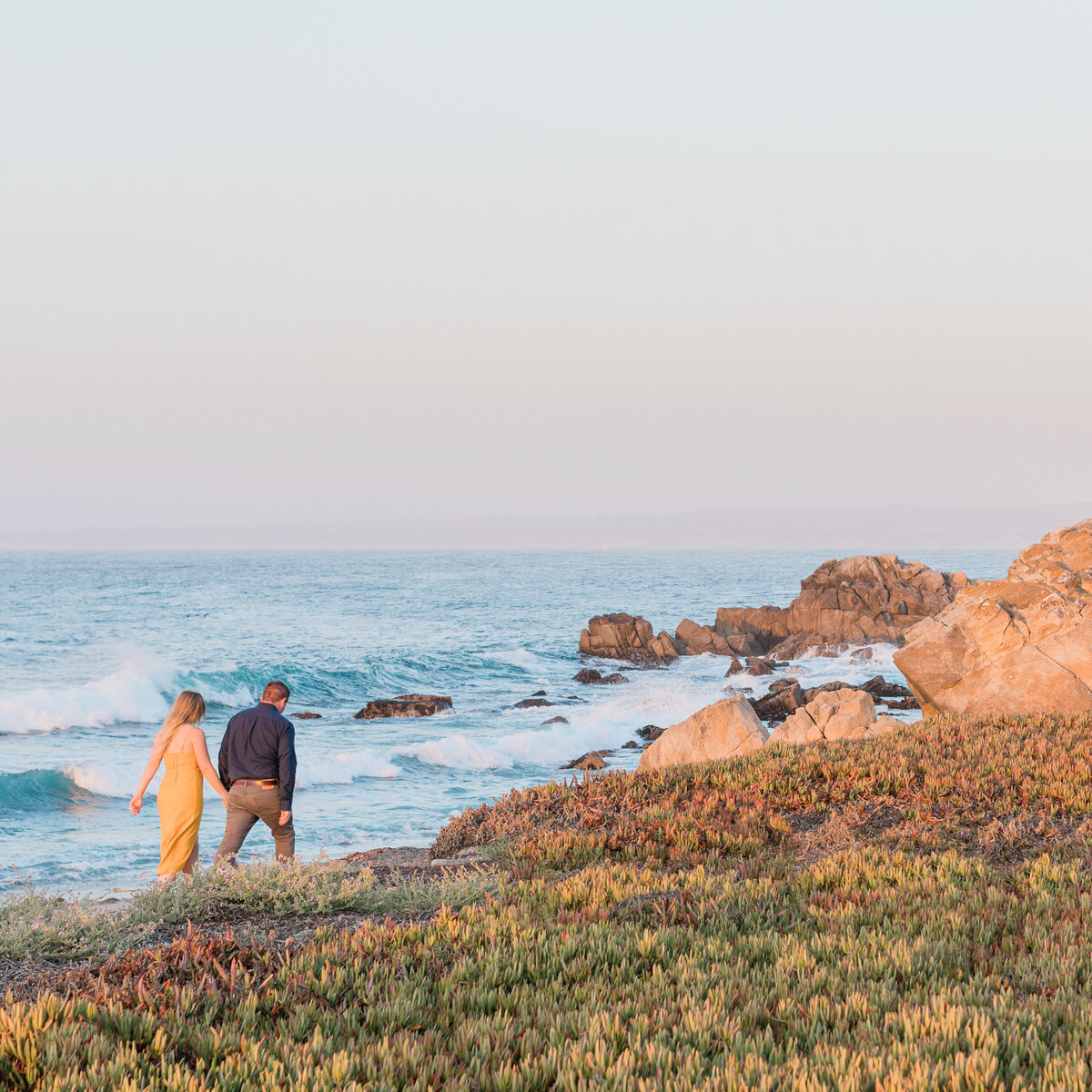 Couple walking along the coast of Pacific Grove