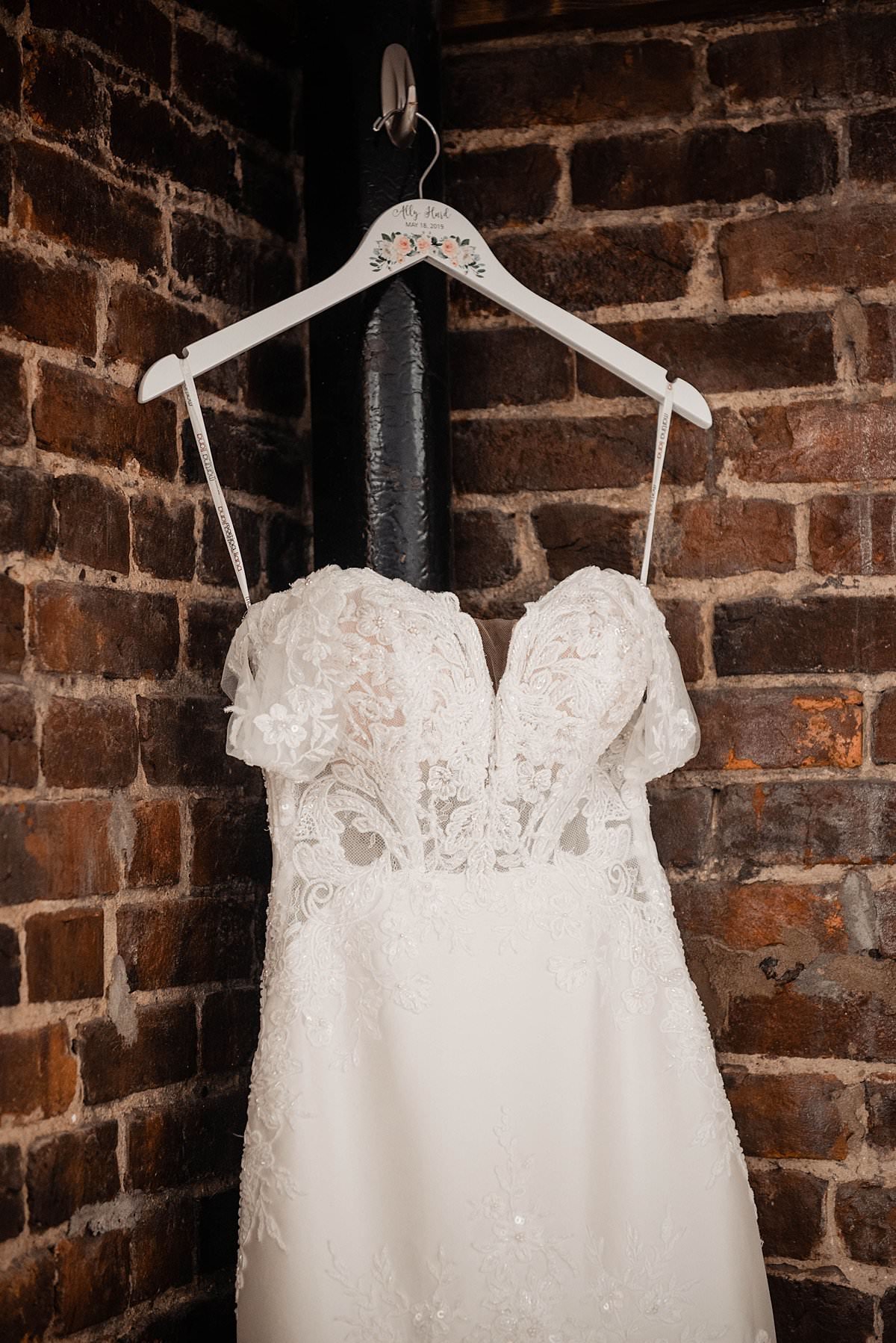 Brides wedding dress hanging from custom hanger