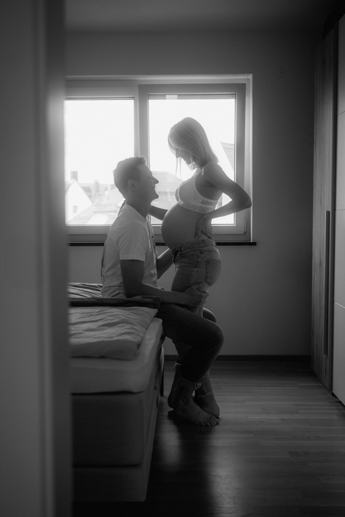 Private picture of a bedroom maternity photography with mom and dad to be.