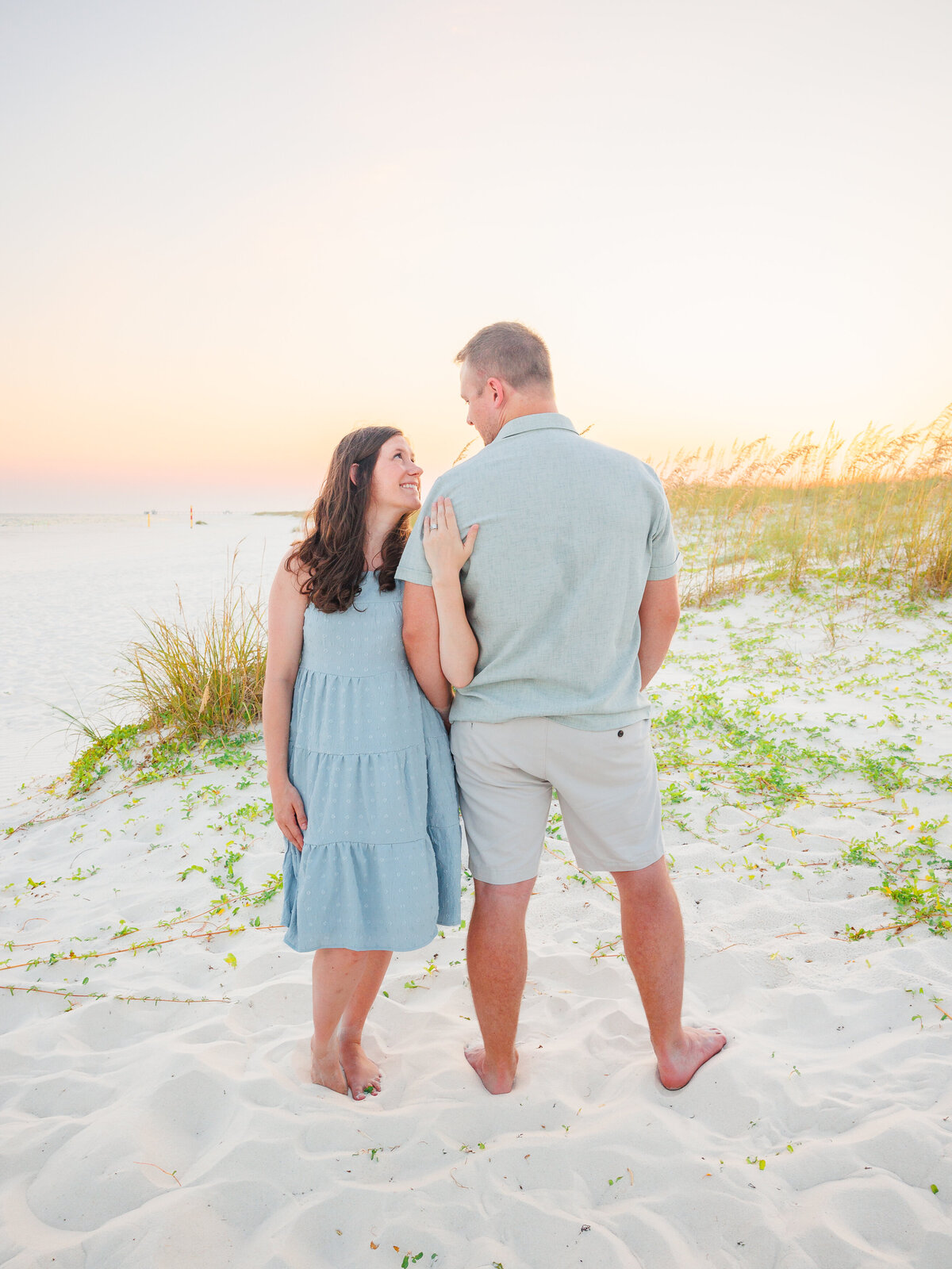 Couple standing in front of sunset at beach