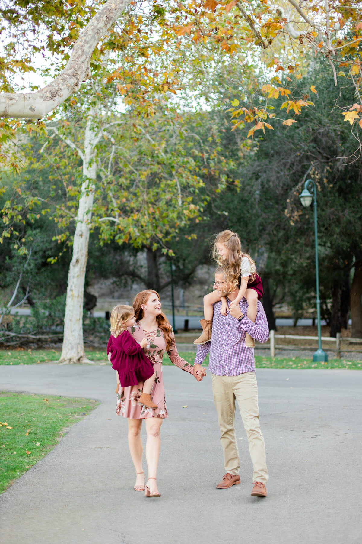 dad walks with daughter on shoulders