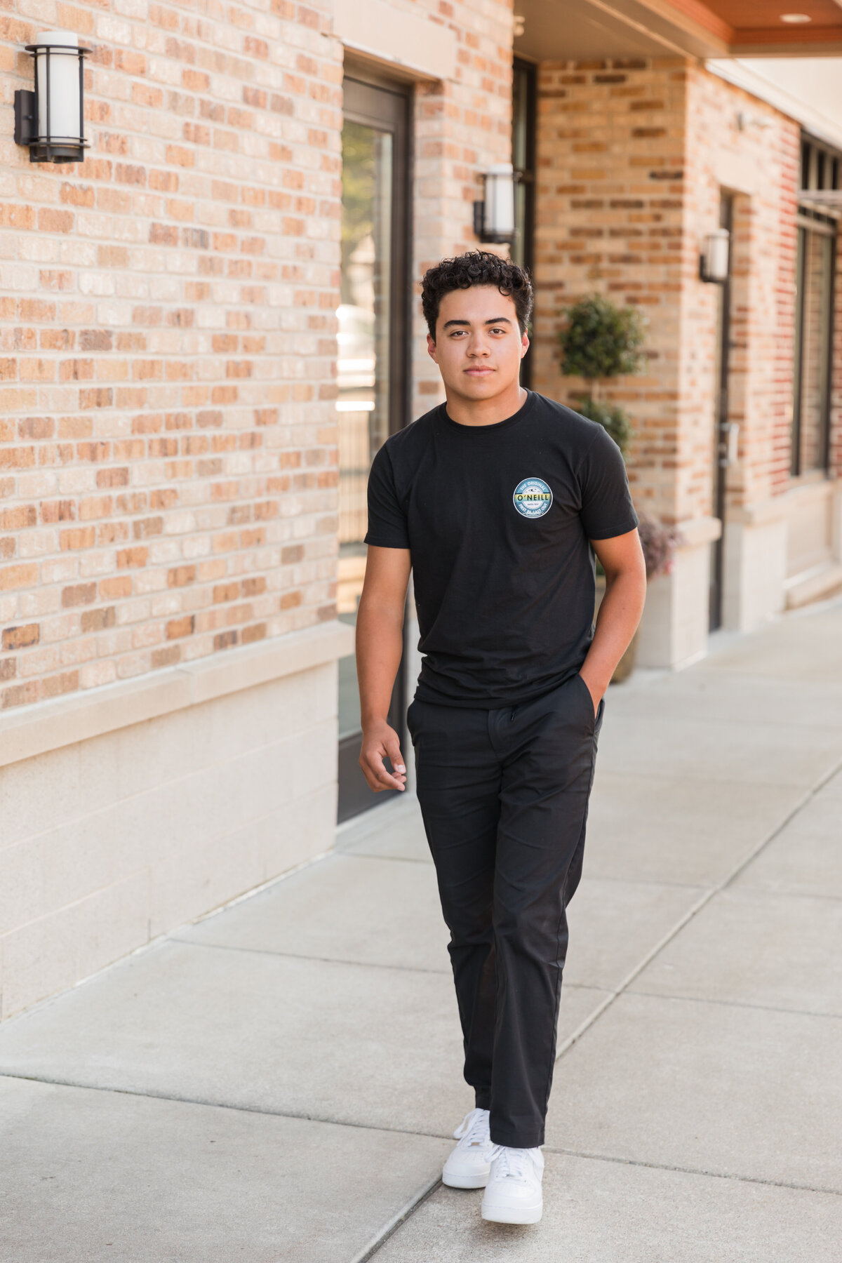 Senior guy walking along the sidewalk and smiling at the camera