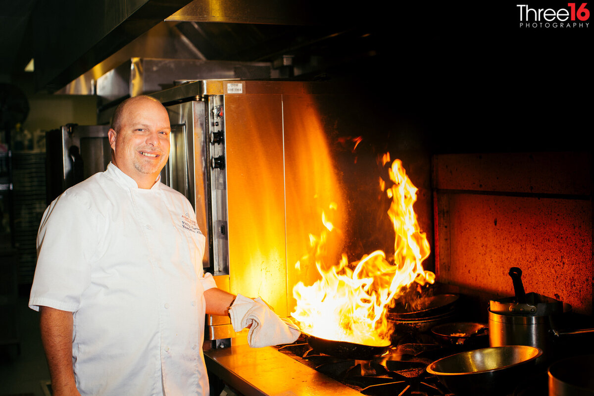 Corporate photo of a chef posing as his pan flames up