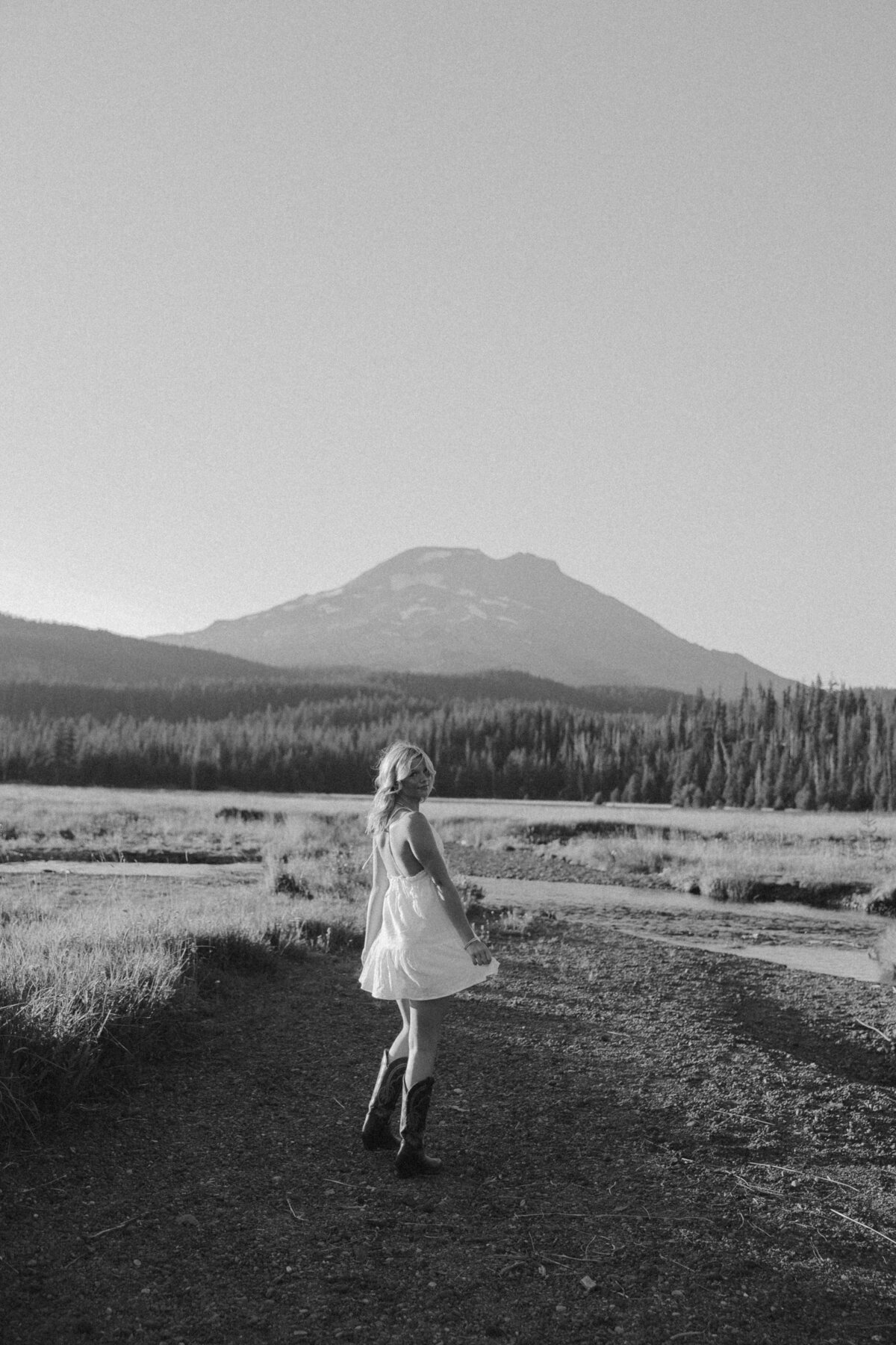 Joyful Senior Portrait in Nature Wearing Navy Dress and Gold Jewelry