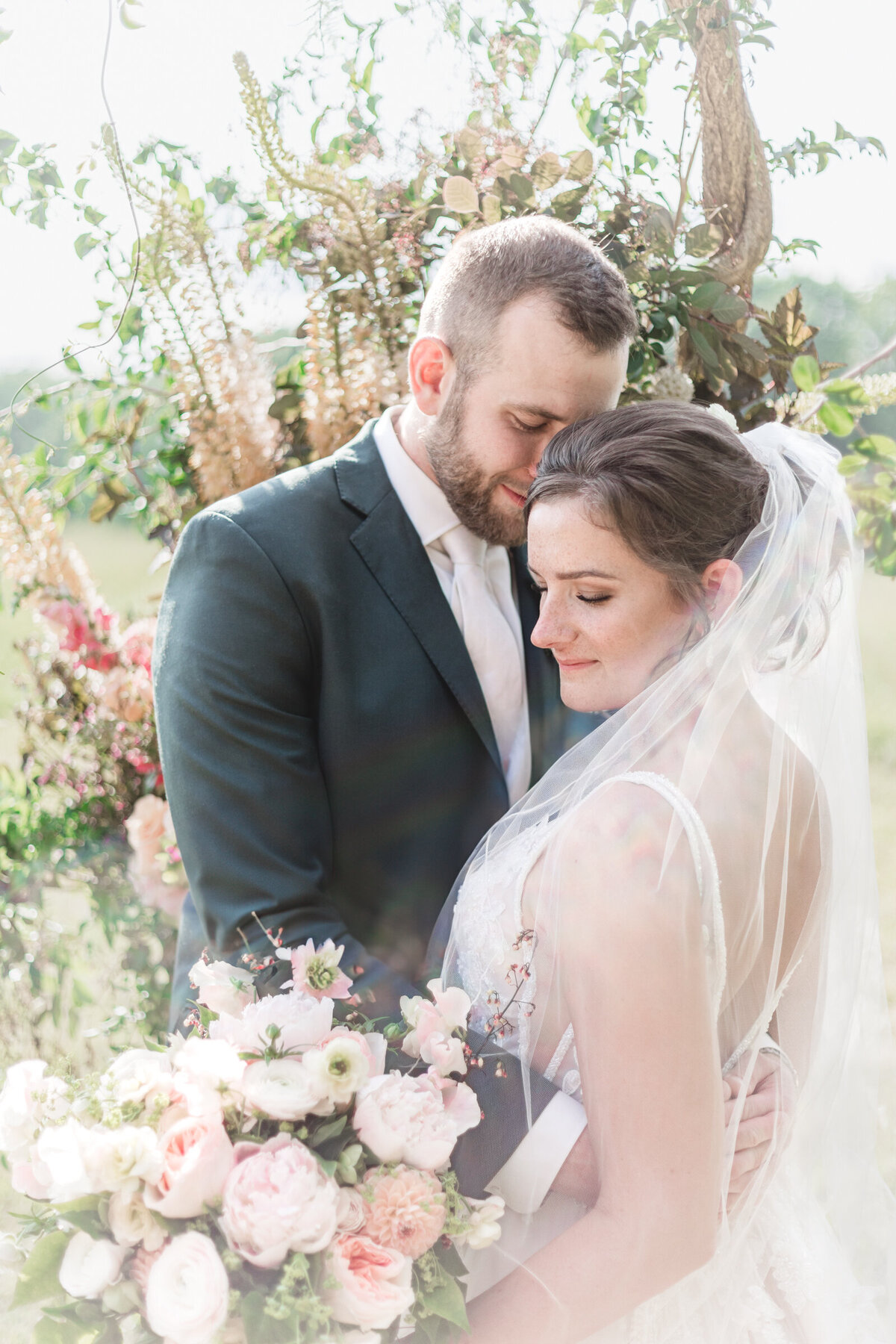 A portrait of a bride and groom  on their wedding day surrounded by flowers