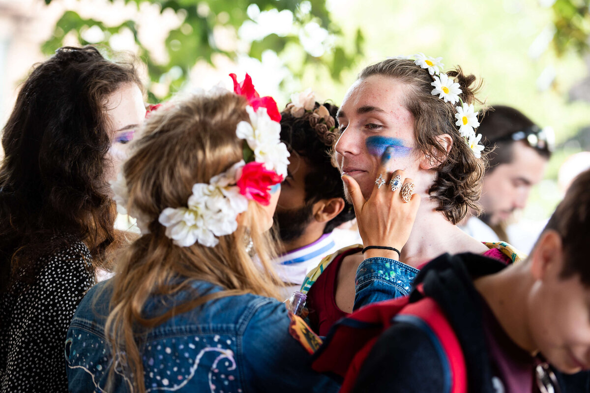 a female putting pride makeup paint on an attendee of the Tweed Canopy Growth Pride Parade.  Captured by Ottawa Event Photographer JEMMAN Photography COMMERCIAL