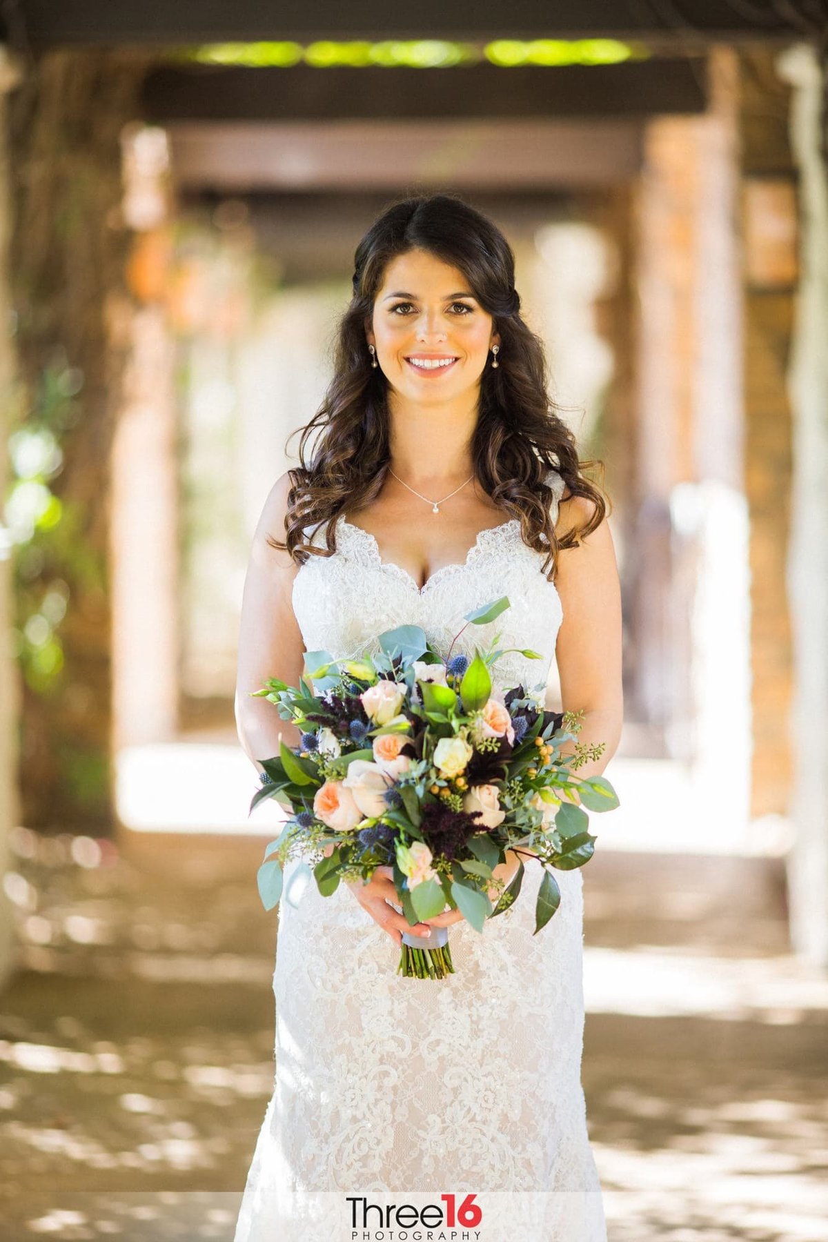 Bride posing for photos with large smile and beautiful bouquet
