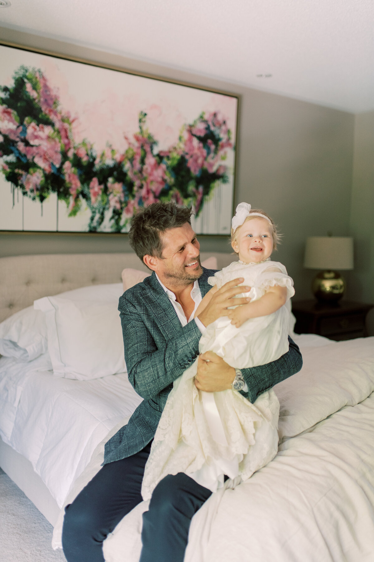 Father-daughter joy inside their Oakville home, just moments before the christening ceremony begins.