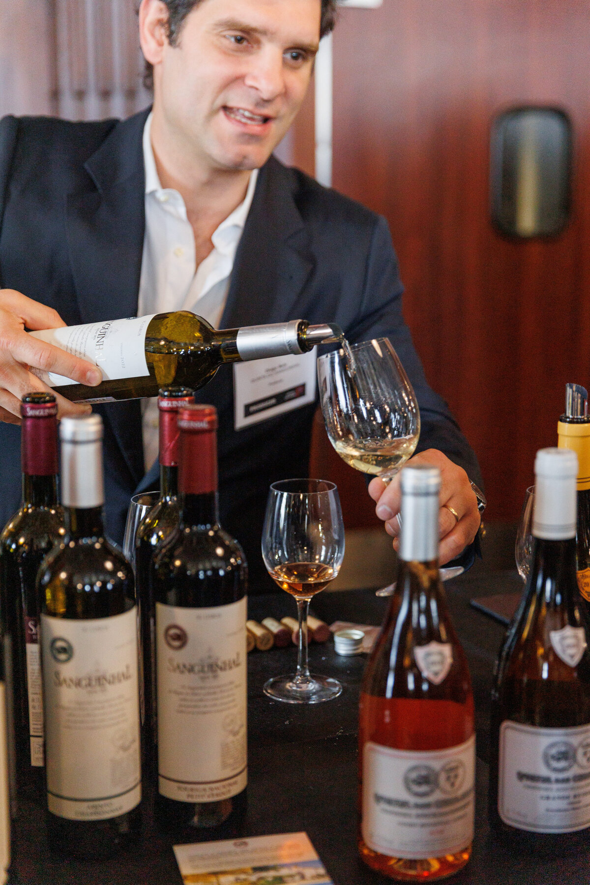 Male talking  holding a bottle of wine