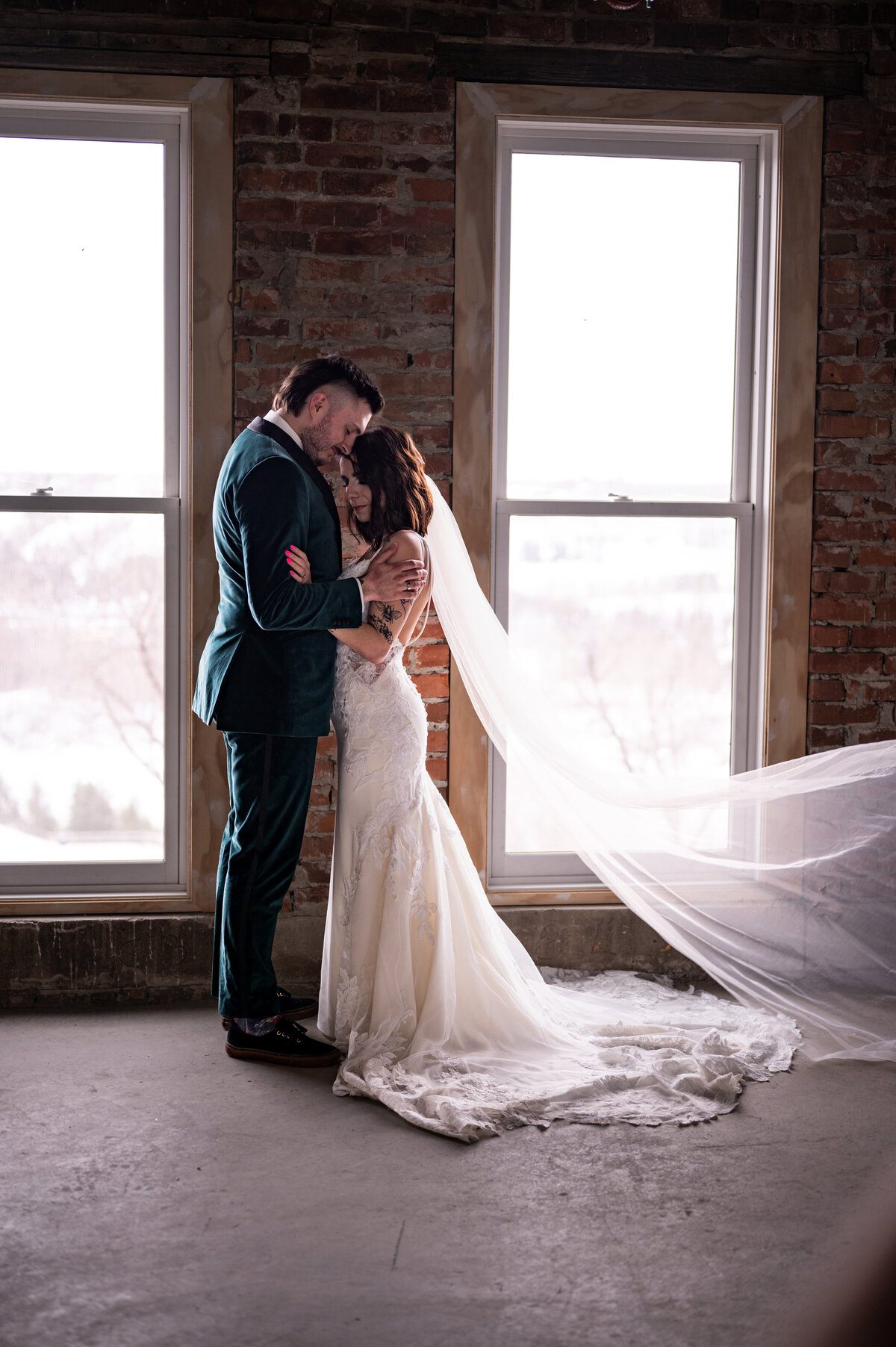 Pendennis Building wedding in front of large windows and brick walls
