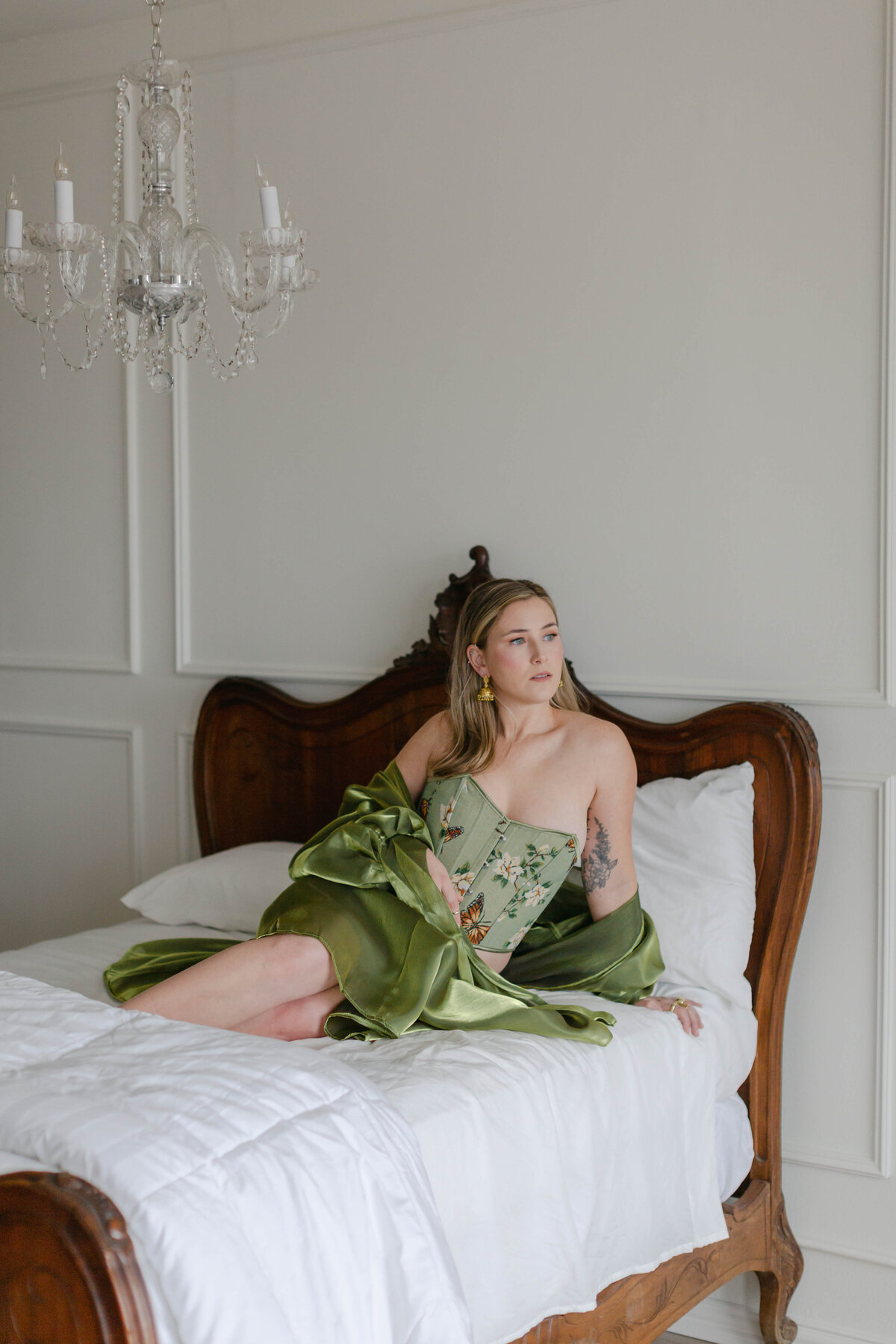 woman sitting on bed in green lingerie