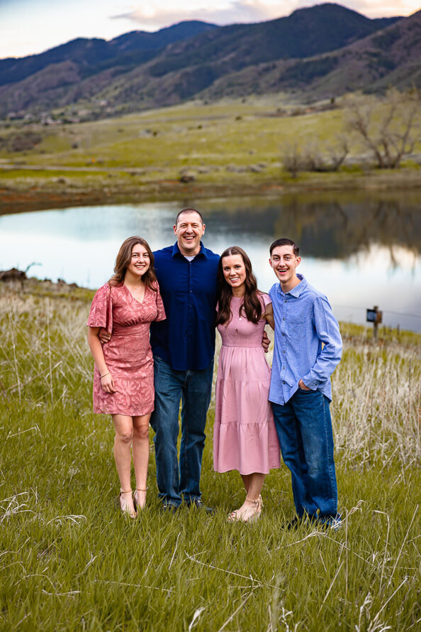 A family of four smiles for the camera in front of a lake in Colorado.