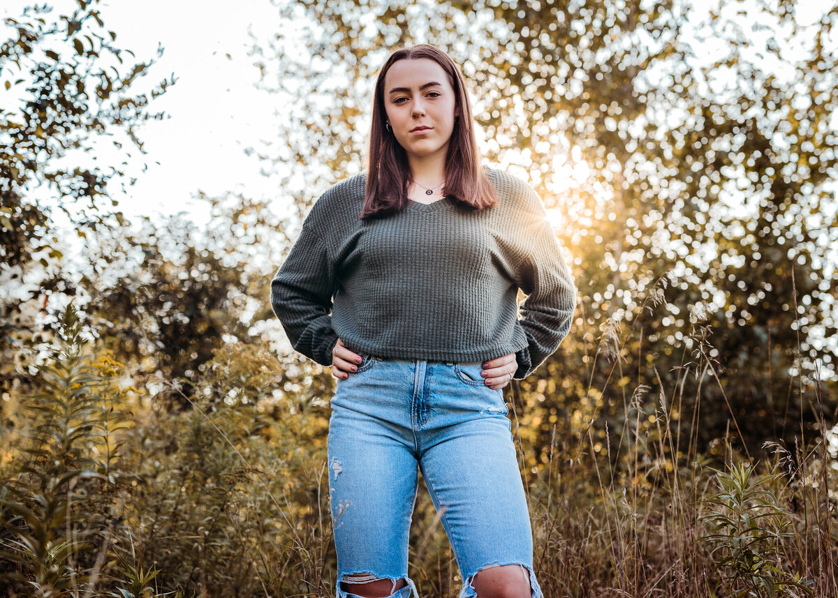 Concord High School senior posing for senior portraits with jeans and sweater by lisa smith photography