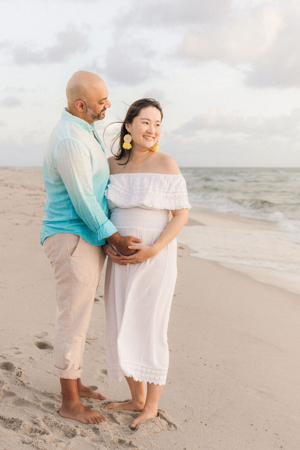 Expecting couple standing together during a beach maternity session in Miami, South Florida.