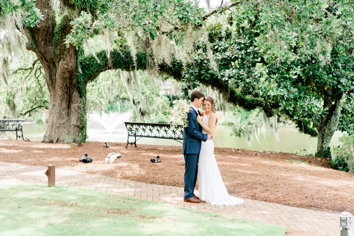Bride and groom posing under Spanish moss in Alabama
