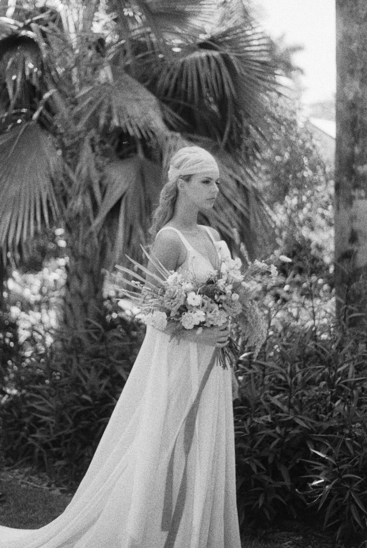 Headscarf bride stands at the ready with her bouquet, confident in her mistakes in black and white.