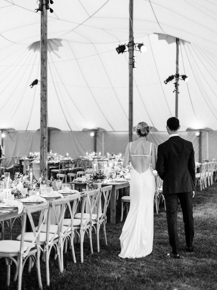 bride and groom walking around their wedding reception tent wedding tables under the tent at weekapaug inn