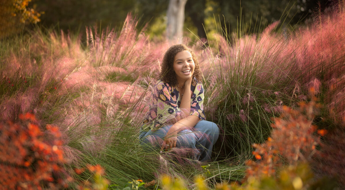 Senior girl laughing in colorful bushes