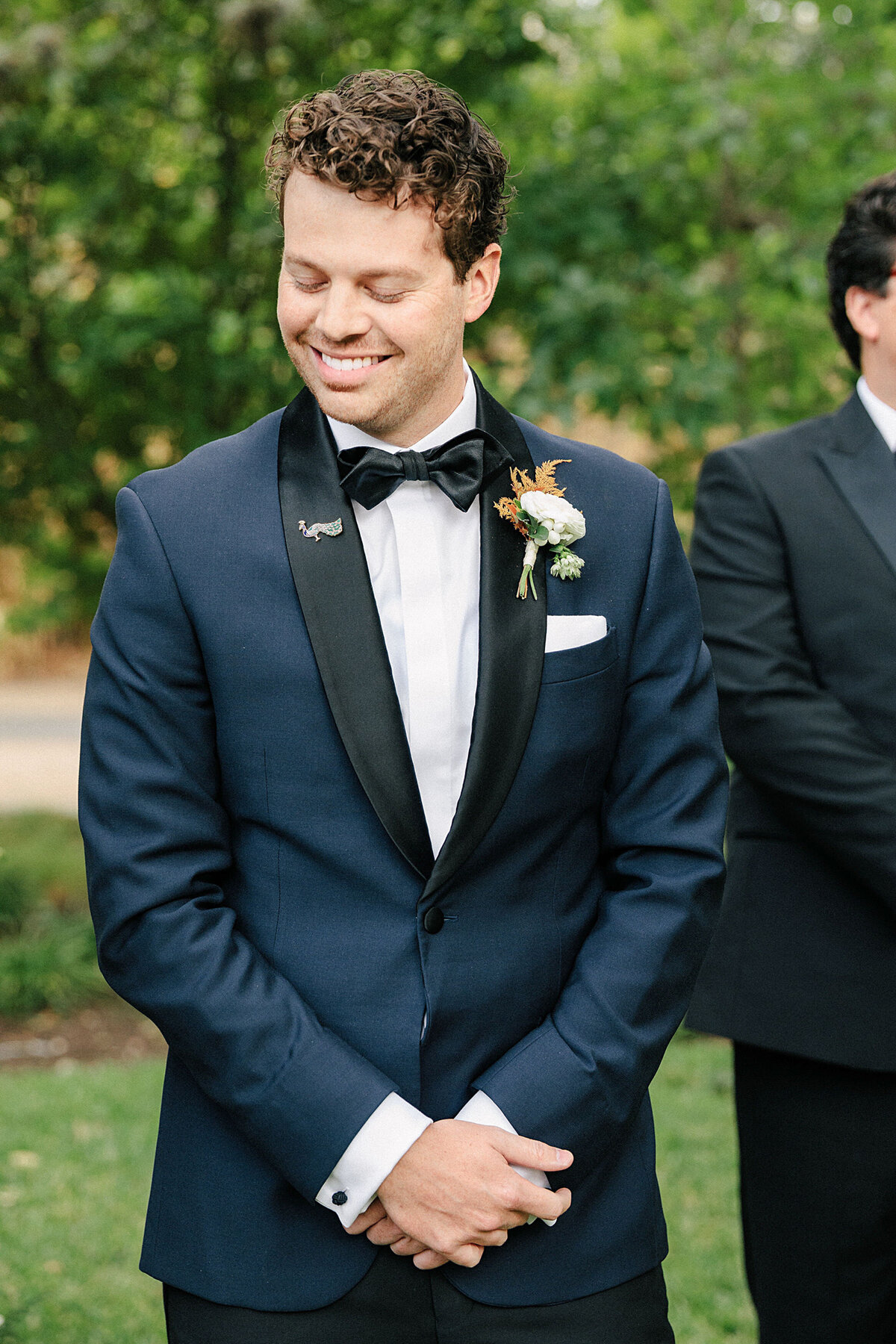 Groom smiling in navy blue tuxedo