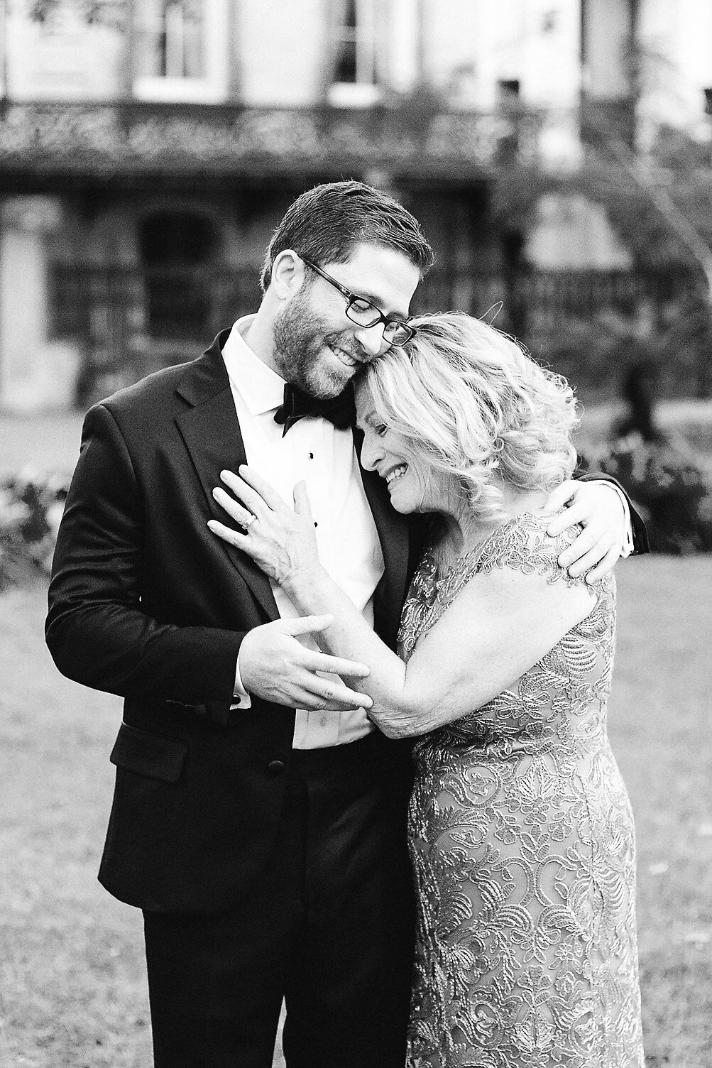 Groom comforting crying mother.