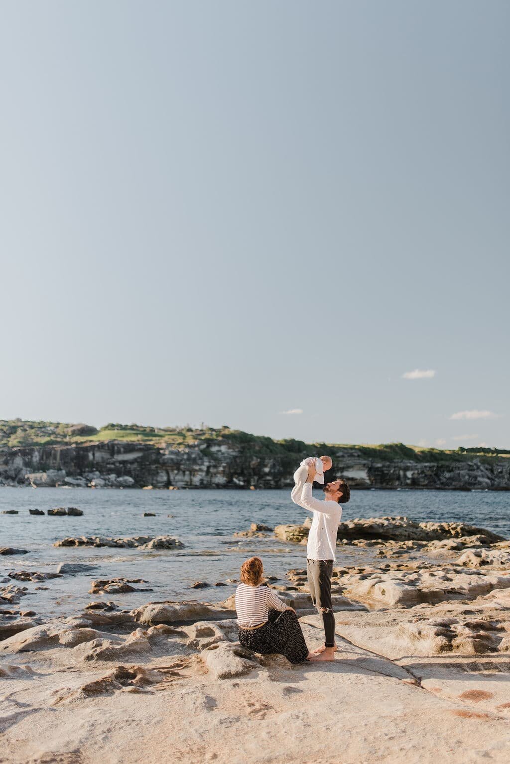 Family-calm-afternoon-walk-sydney-beach-dad-swinging-baby