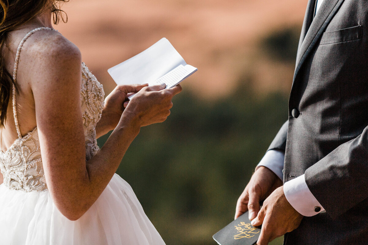 the bride laughs while getting her hair curled. her dress hangs beside her