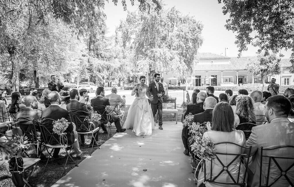 Bride and groom smile and guests watch seated still.  By Peach Portman destination wedding photographer