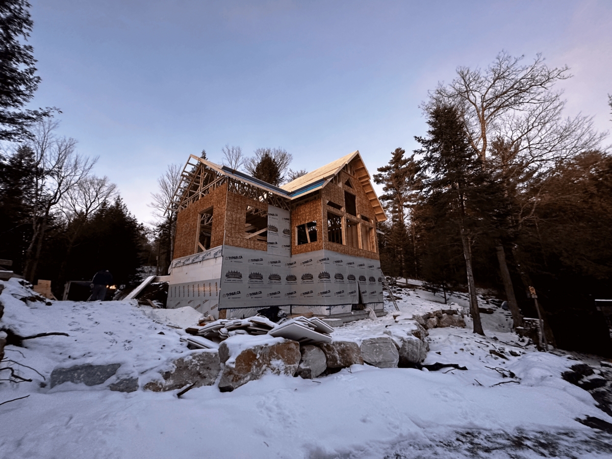 Expertly built Haliburton Highlands home with detailed exterior woodwork and scenic views of the surrounding landscape.