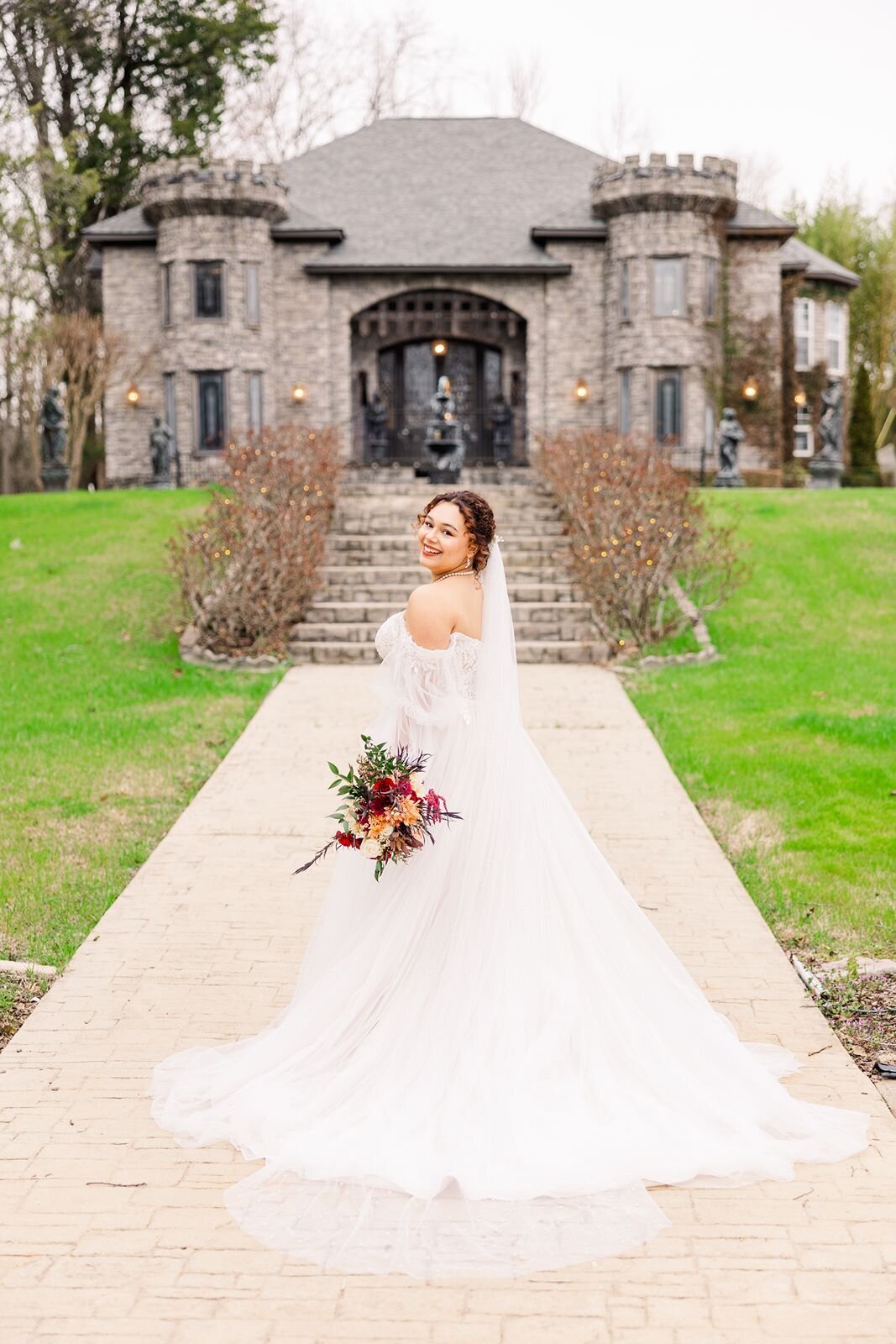Bride standing in path in front of a castle wedding venue