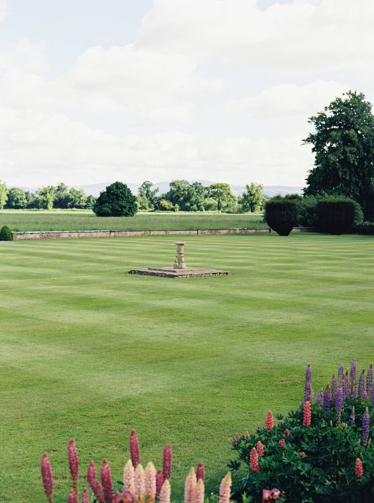 a wedding photo showing the gardens and manicured lawns at Luttrellstown Castle in Ireland