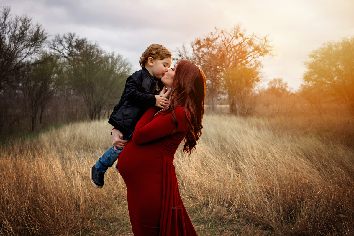 Experience winter extravaganza with our styled maternity session near San Antonio. Our mom-to-be's scarlet flying dress adds a touch of magic to your family's winter memories.