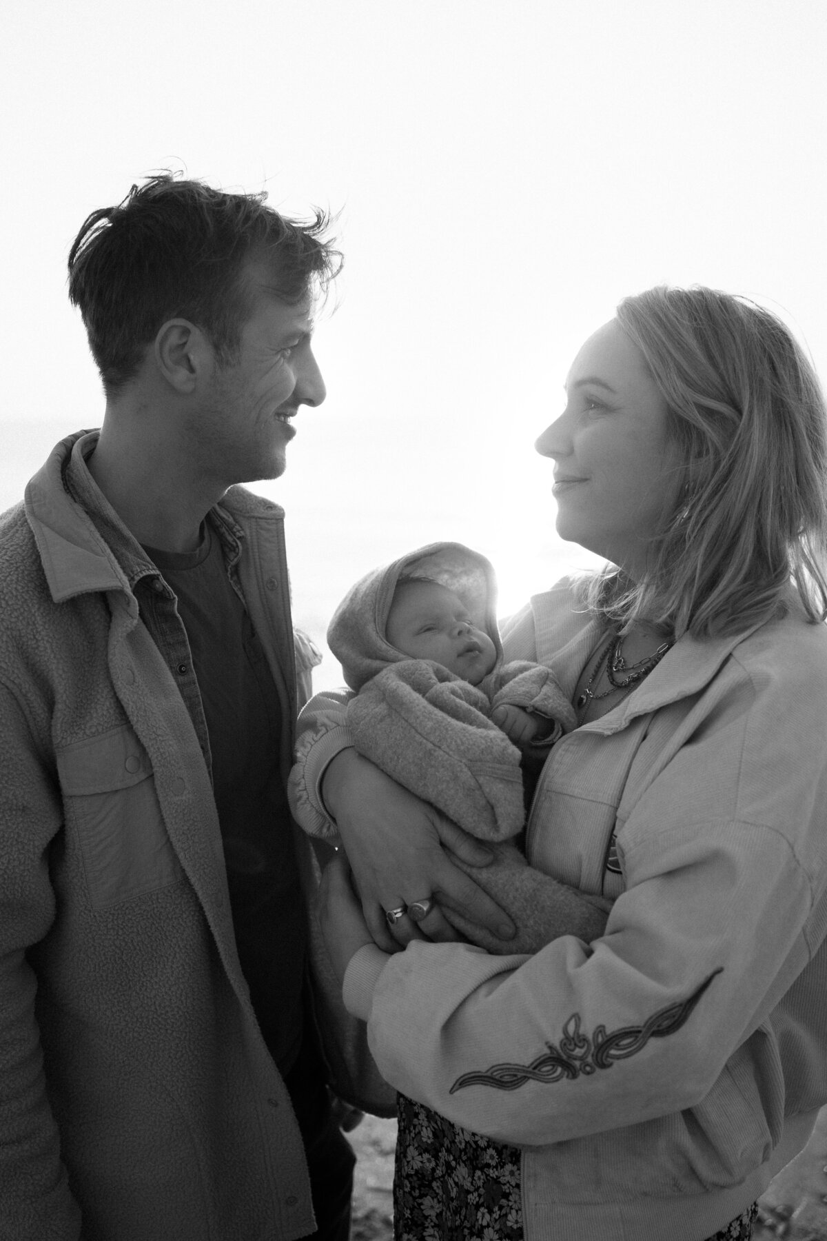 Newborn fotografie van een baby van enkele weken oud, vastgelegd in huis en aan zee. Intieme momenten van een pasgeboren baby, vol met de heerlijke chaos van het gezinsleven.