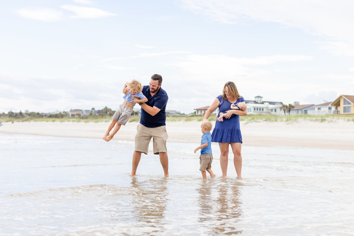 Family of five playing in the water during a family photography session in Ponte Vedra Beach
