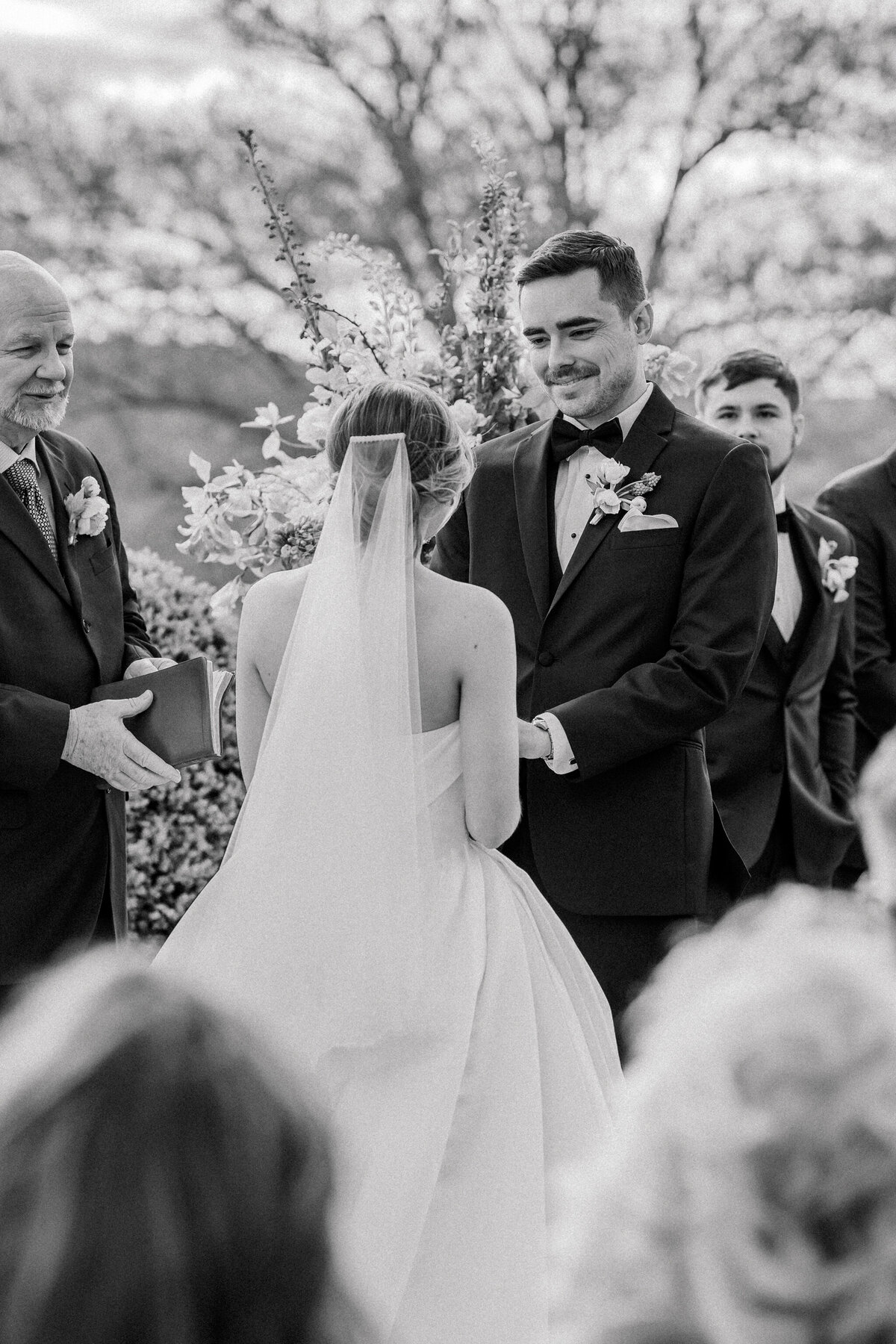 Wedding at the Estate at River Run in Maidens, VA | Wedding Photographer in Richmond | black and white image of groom emotionally looking at bride while holding hands during their Estate at River Run wedding ceremony