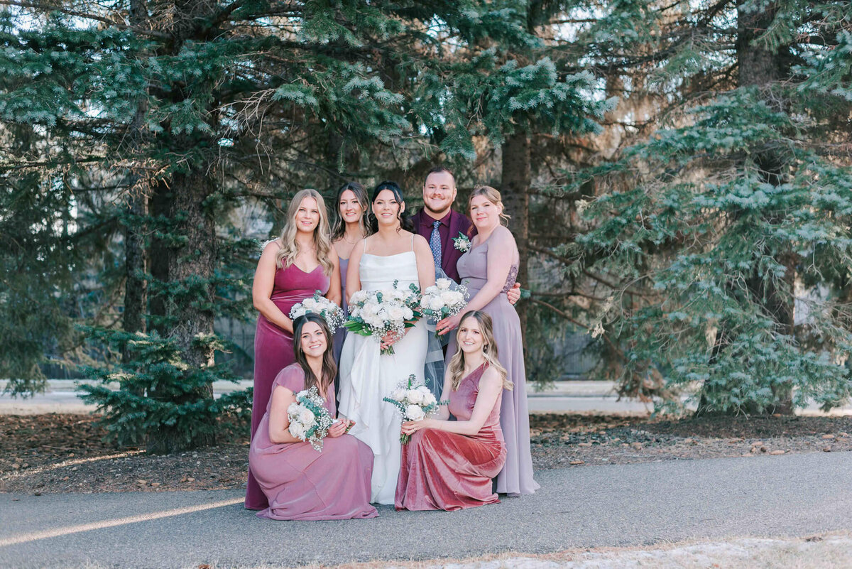 Bridal is surrounded by her bridesmaids and man of honour.