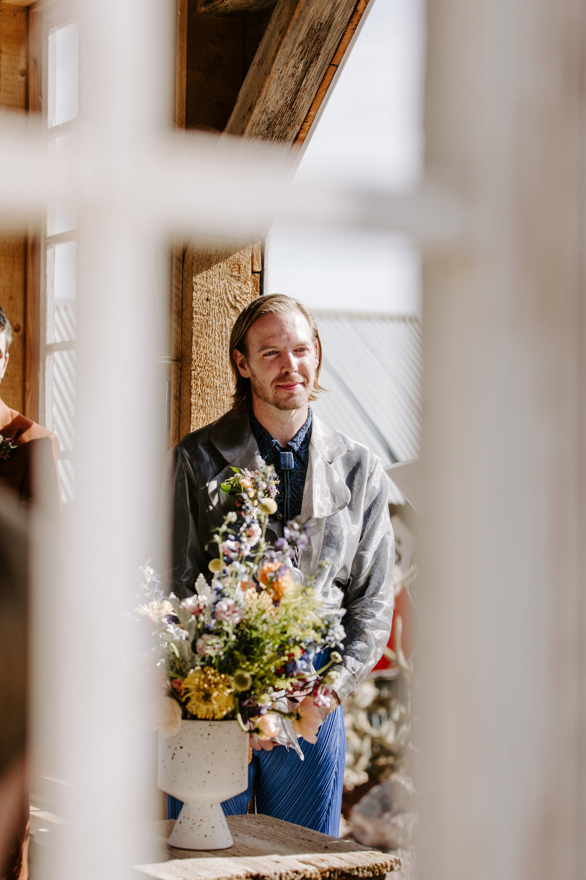 A person stands happily on their wedding day.