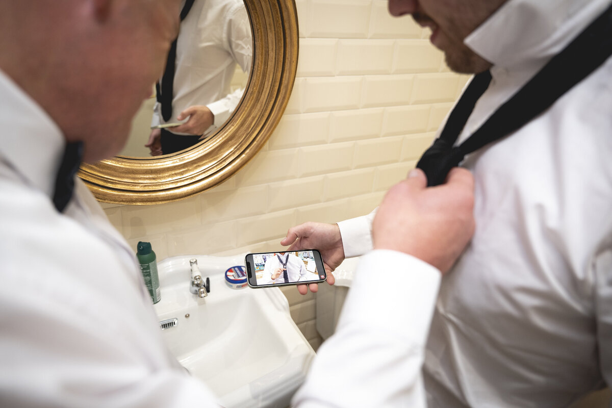 Groomsmen watching a youtube video to help them with their ties