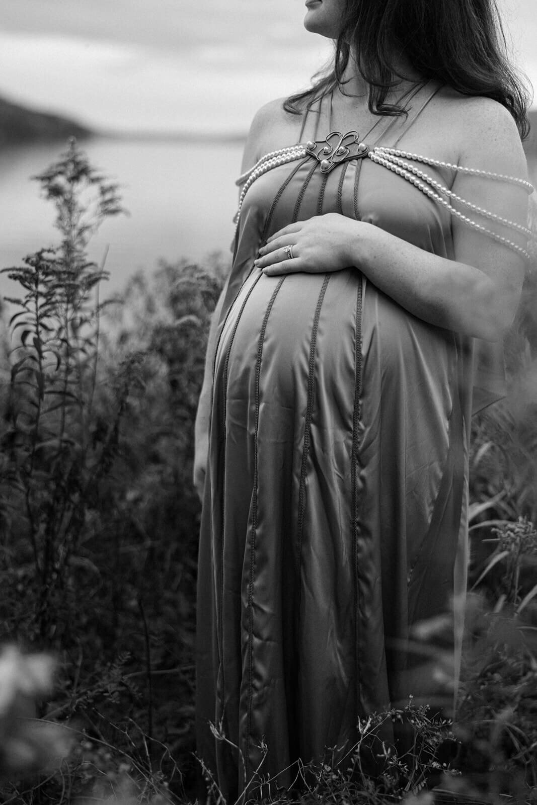 Woman resting hand on baby belly for maternity photo session in Fingerlakes, NY
