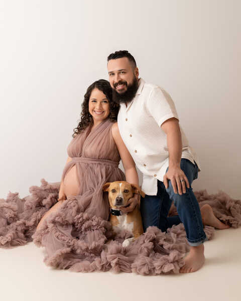 Couple sitting with newborn props during Houston maternity family portraits.