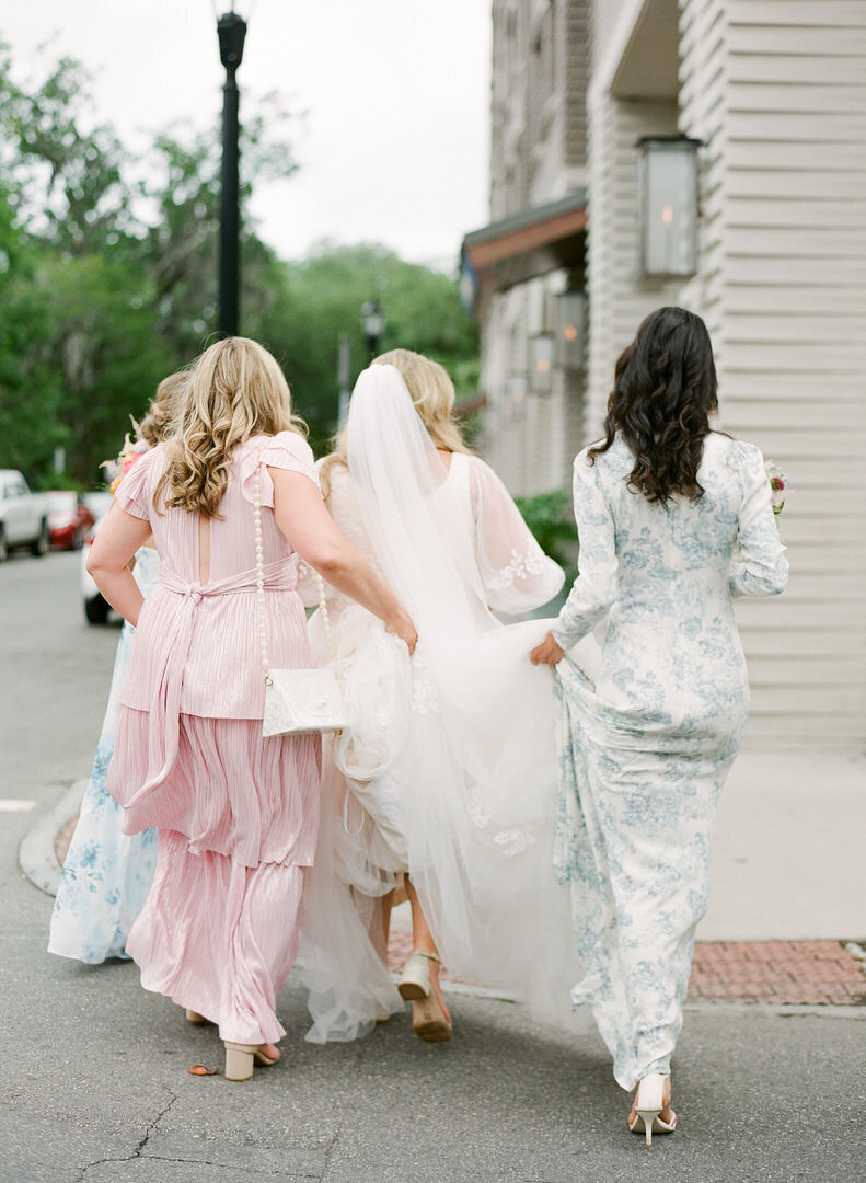 Bridesmaids and Bride Walking Across Street Photo