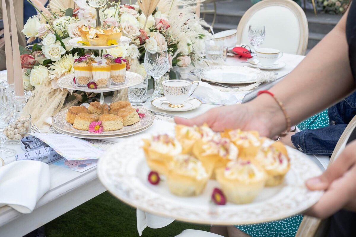 Vintage table setting for afternoon tea, gold rimmed plate with mini desserts