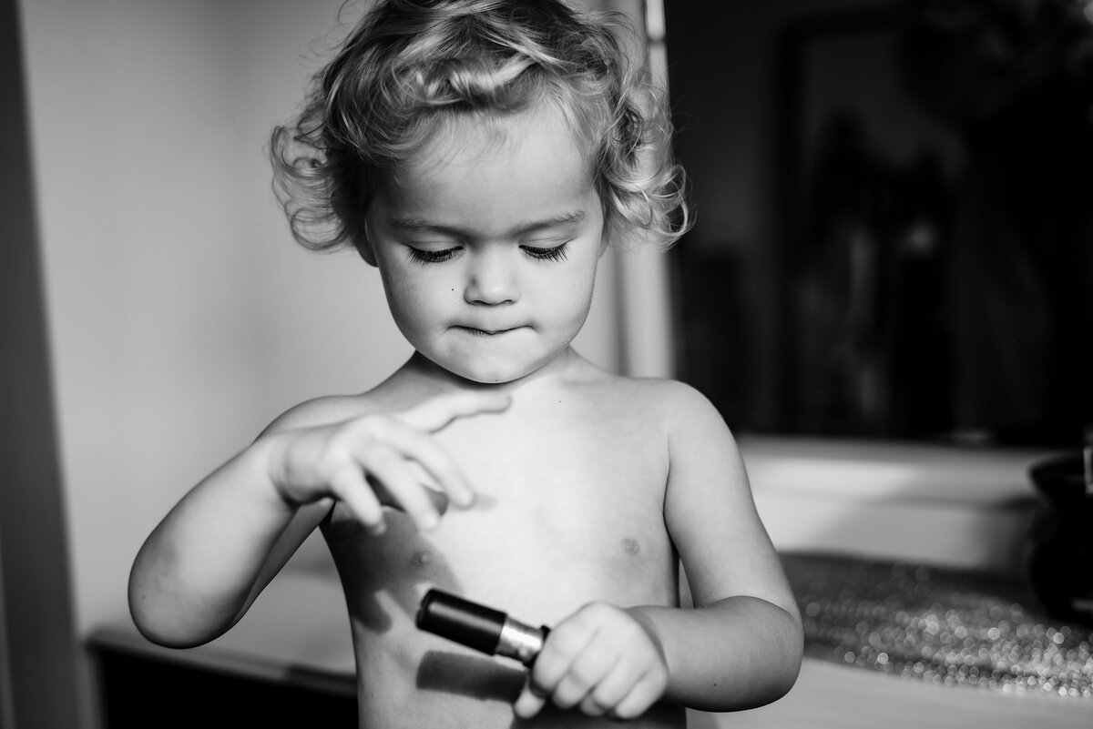 little girl playing with mkae up during family photoshoot