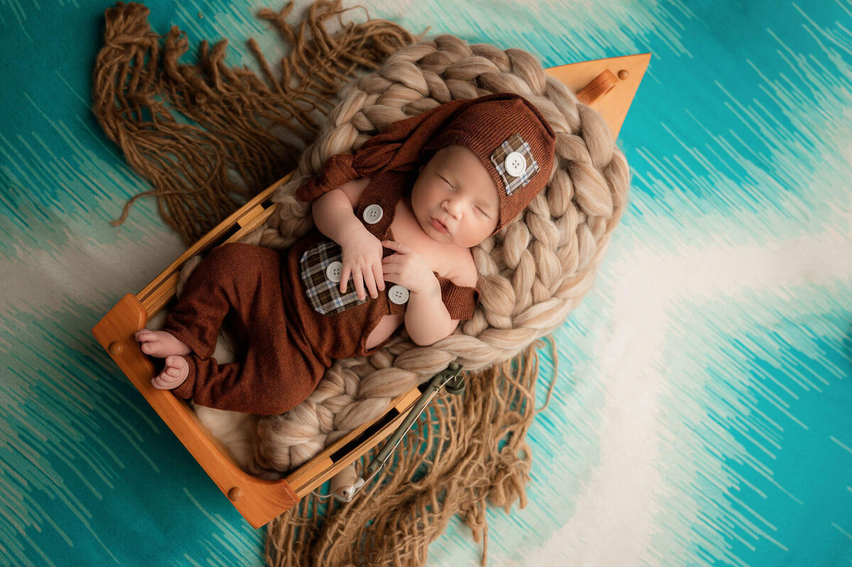 Toronto Newborn photo of baby newborn boy sleeping in a boat prop.