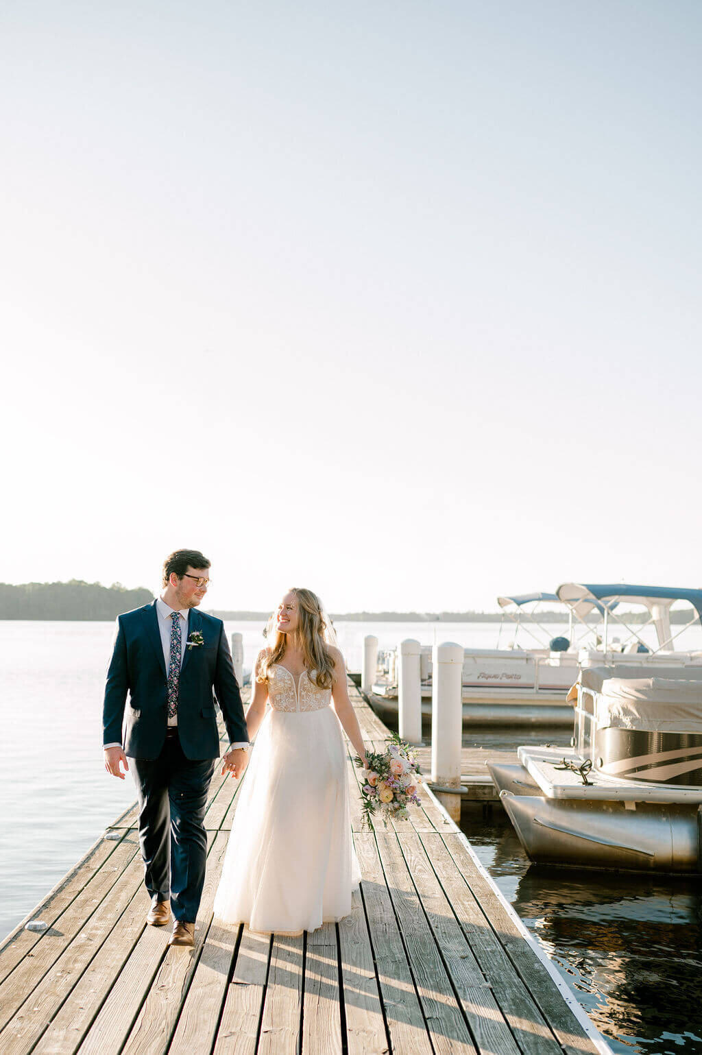 Bride and groom walking along a pier located on the Potomac River