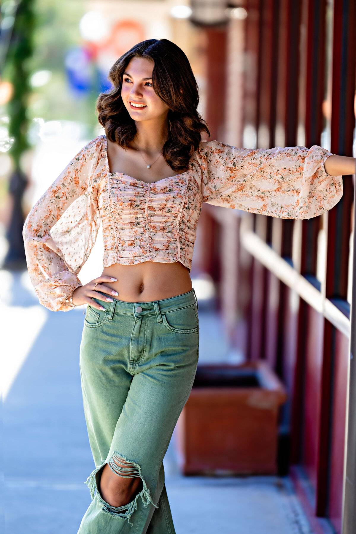 Urban-inspired senior portrait in trousers and blush colored top in downtown setting