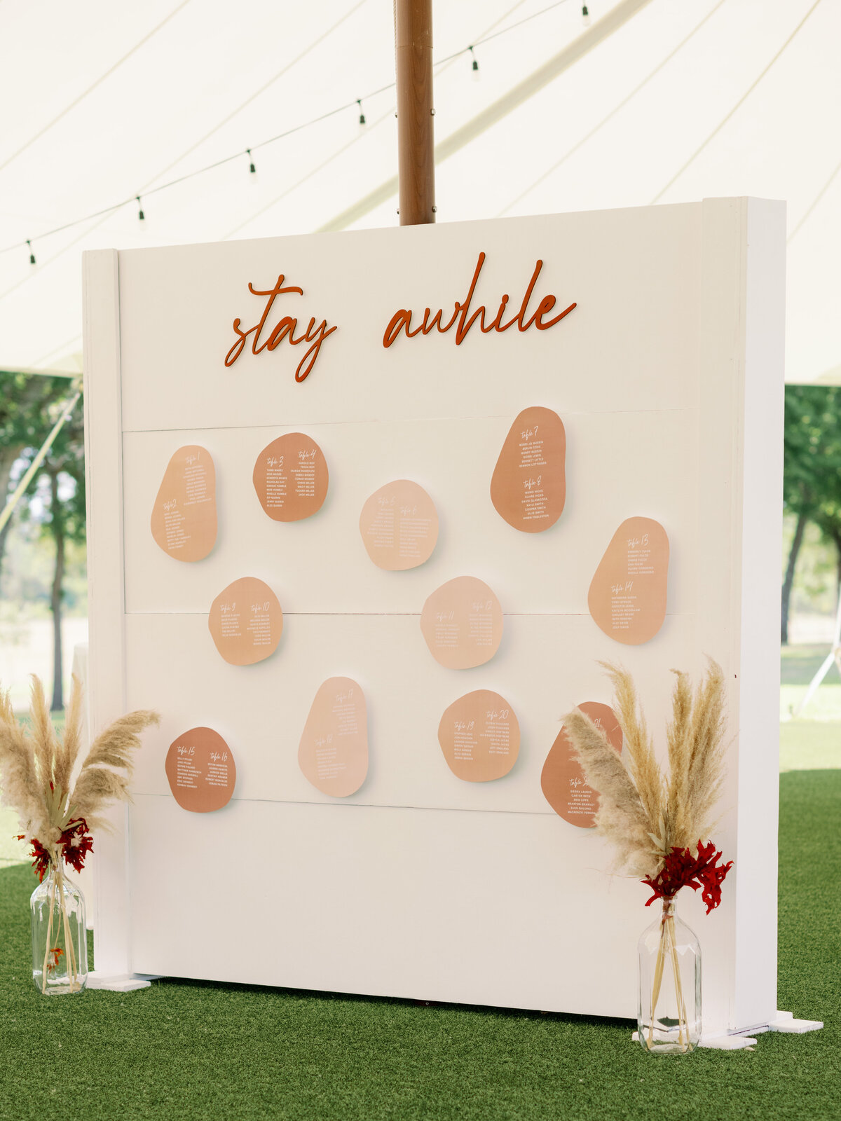 White and neutral colored wedding seating chart backdrop with abstract shapes